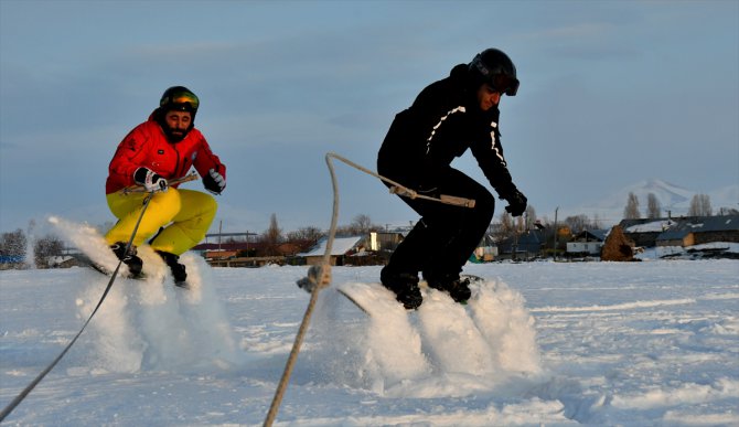 Köyde yaşayan gençlerden arazi aracıyla karda snowboard