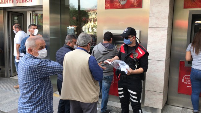 Adana'da polis, banka önlerinde sıra bekleyenlere maske dağıttı