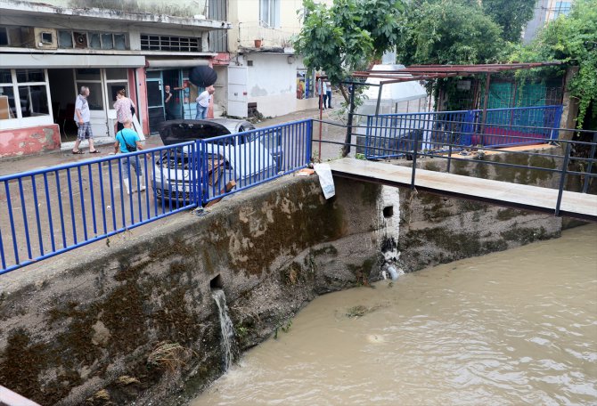 İzmir'de sağanağın ardından derenin taşmasıyla bazı dükkan ve otomobiller su altında kaldı