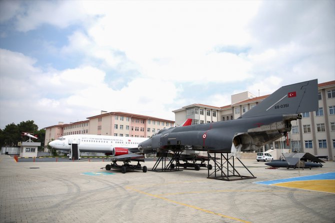 Bahçesinde yolcu ve savaş uçağı olan okul
