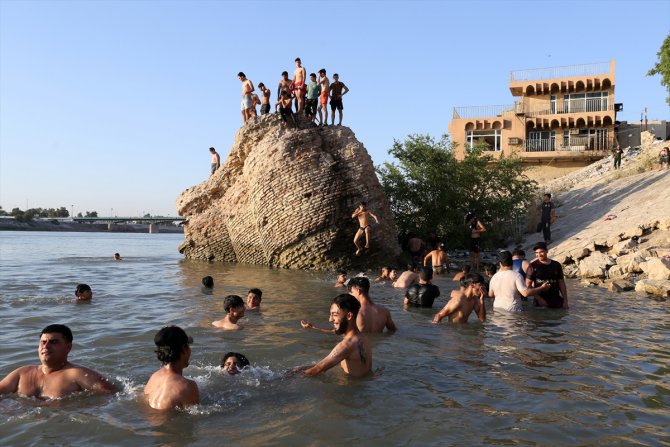 Hava sıcaklığının 50 dereceye ulaştığı Bağdat’ta halk, çareyi Dicle Nehri'nde serinlemekte buluyor