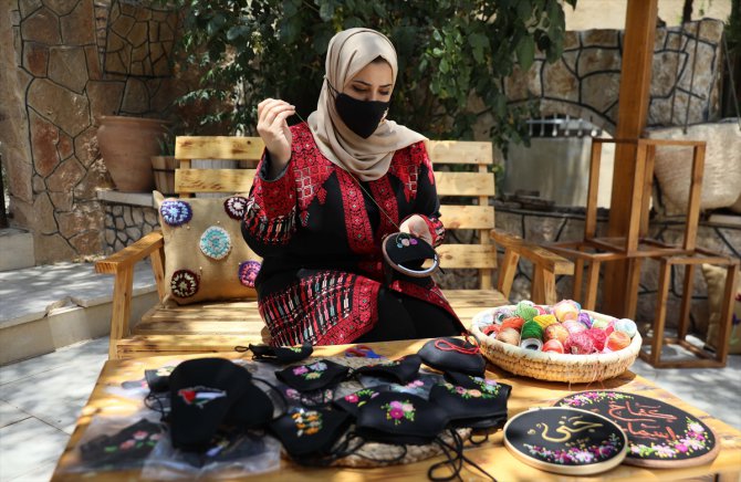 Filistinli genç kadın Kovid-19 maskelerini geleneksel motiflerle renklendiriyor