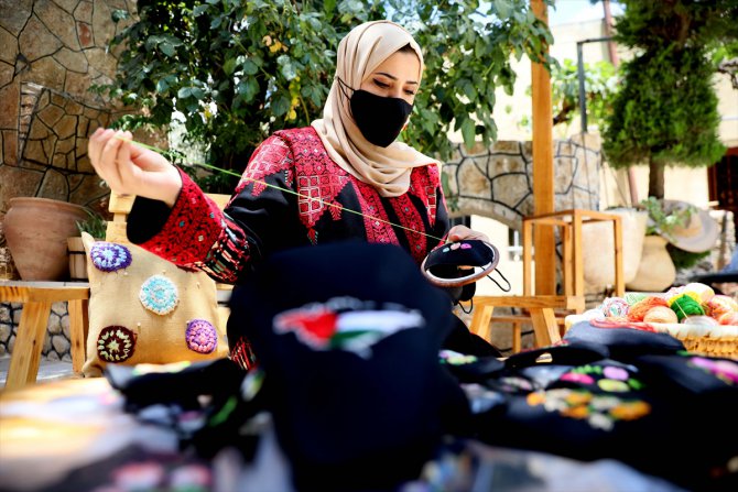 Filistinli genç kadın Kovid-19 maskelerini geleneksel motiflerle renklendiriyor