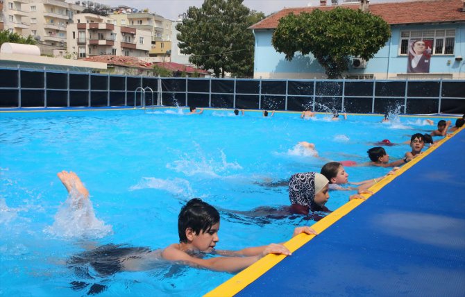 Mersin'de çocuklar okul bahçesinde kurulan seyyar havuzlarda yüzme öğreniyor