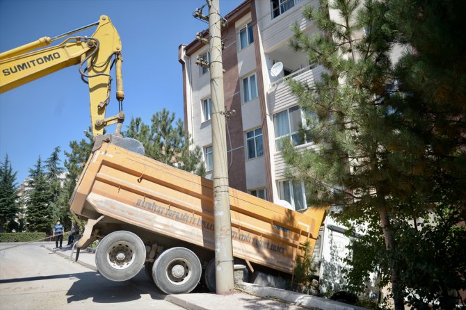 Eskişehir'de park halindeyken hareket eden hafriyat kamyonu apartman boşluğuna düştü
