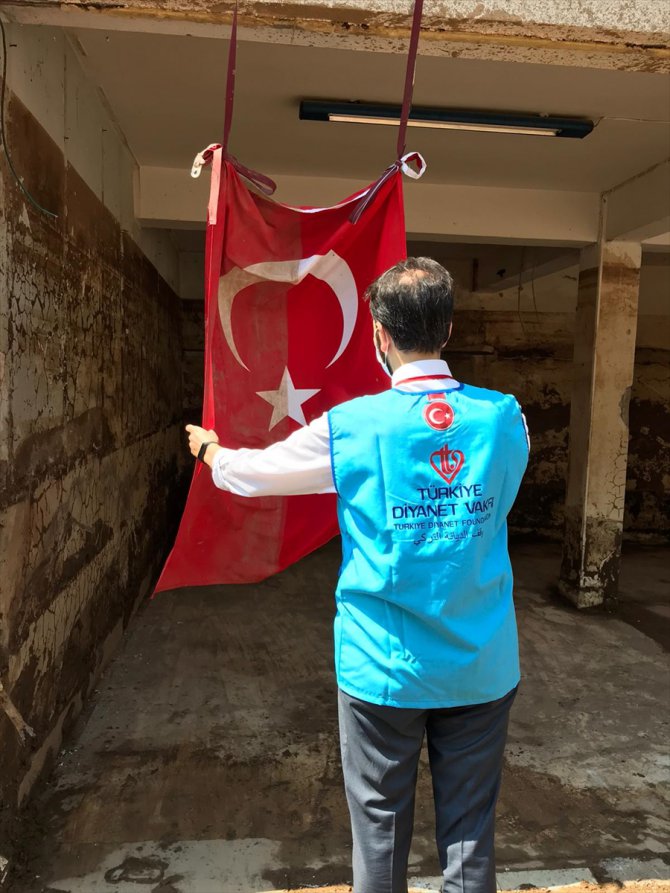 Diyanet görevlilerinin, çamur olan Türk bayrağını temizleme anları kameraya yansıdı