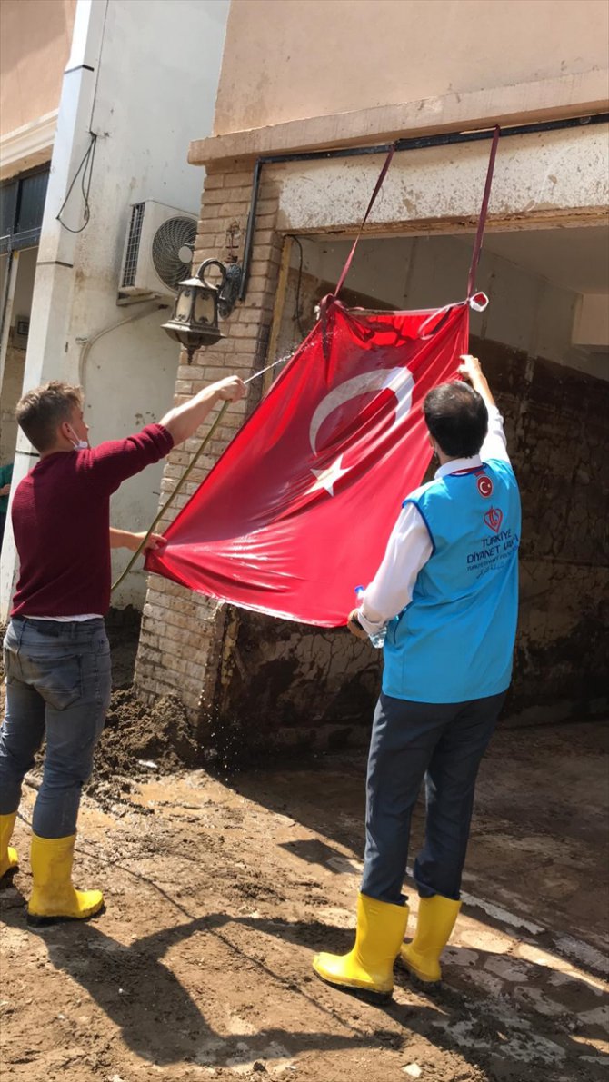 Diyanet görevlilerinin, çamur olan Türk bayrağını temizleme anları kameraya yansıdı