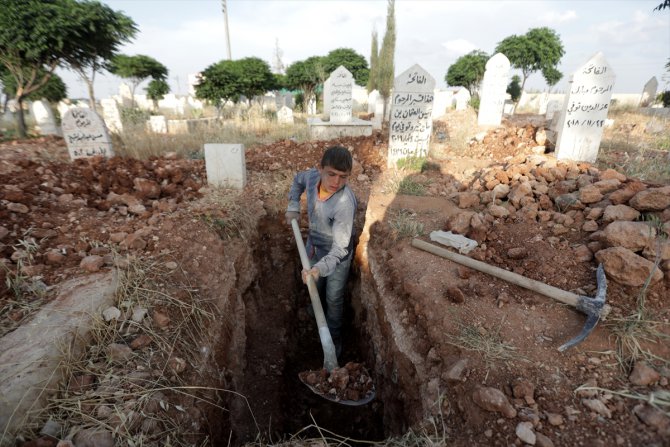 Suriye ordusunun yetim bıraktığı Halepli çocuk ailesine bakabilmek için mezar kazıyor