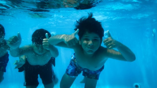 İskenderun'da depremzede çocuklar konteyner kentteki havuzda yüzme öğreniyor